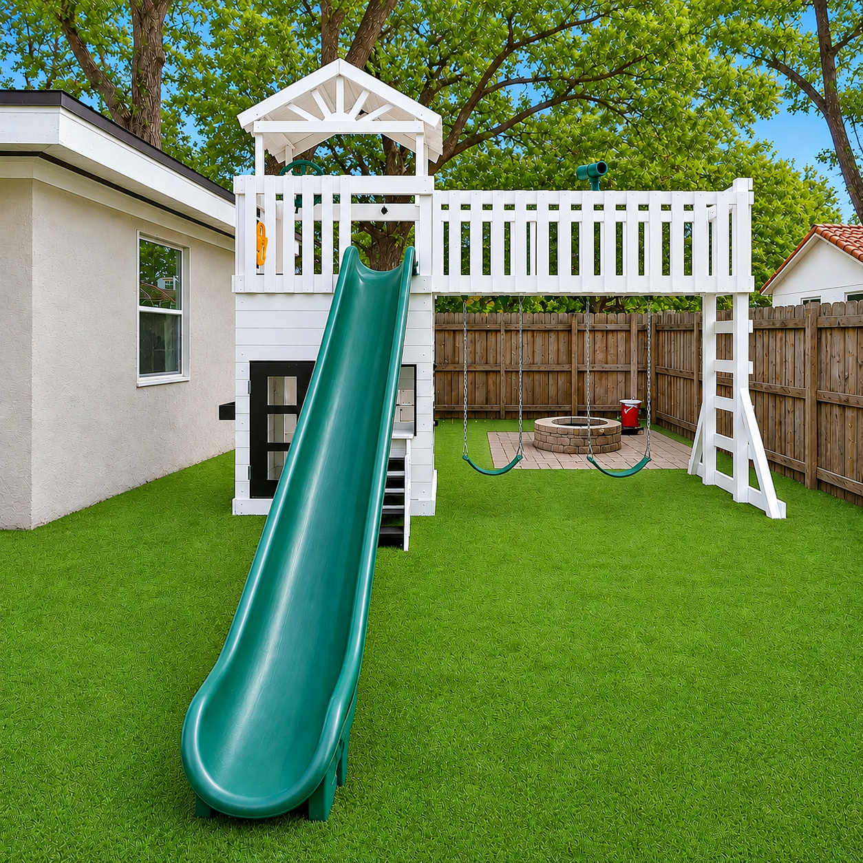 Children's vinyl playset with green slide and white playhouse on a grassy backyard